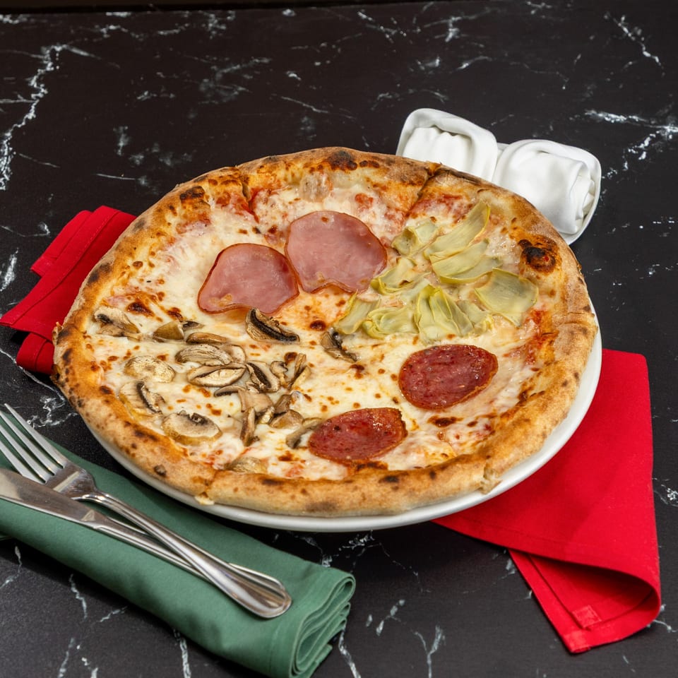 Ti Amo Wood Fired Pizza's Quattro Stagioni pizza with ham, artichokes, mushrooms, and salami.