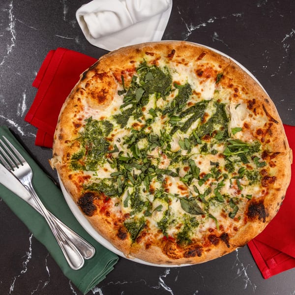 Ti Amo Wood Fired Pizza's pesto chicken pizza with mozzarella, basil, and red pepper flakes.